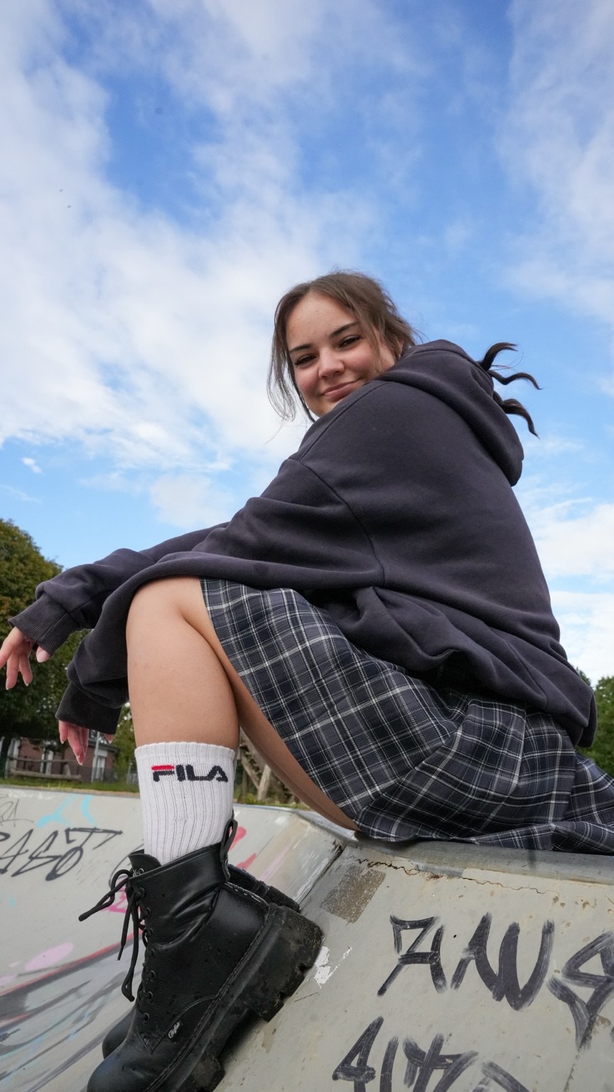 Frau auf einer Graffiti-Rampe unter blauem Himmel